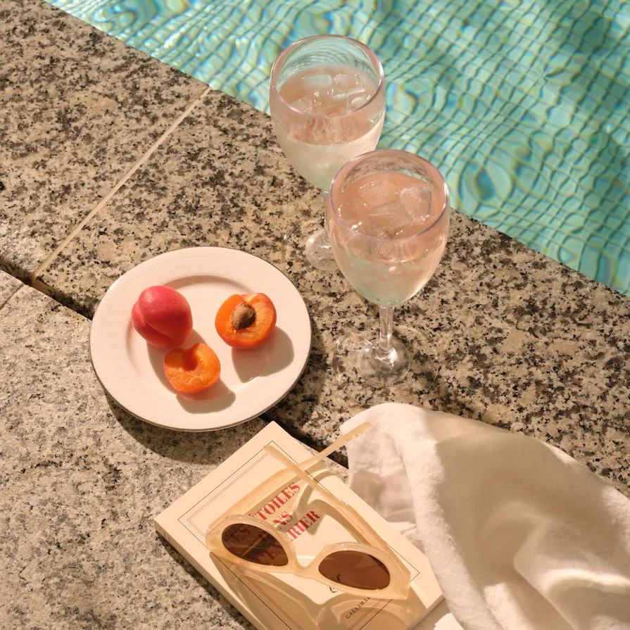 Poolside refreshments with fruit, drinks and a book at The Spa at Coworth Park