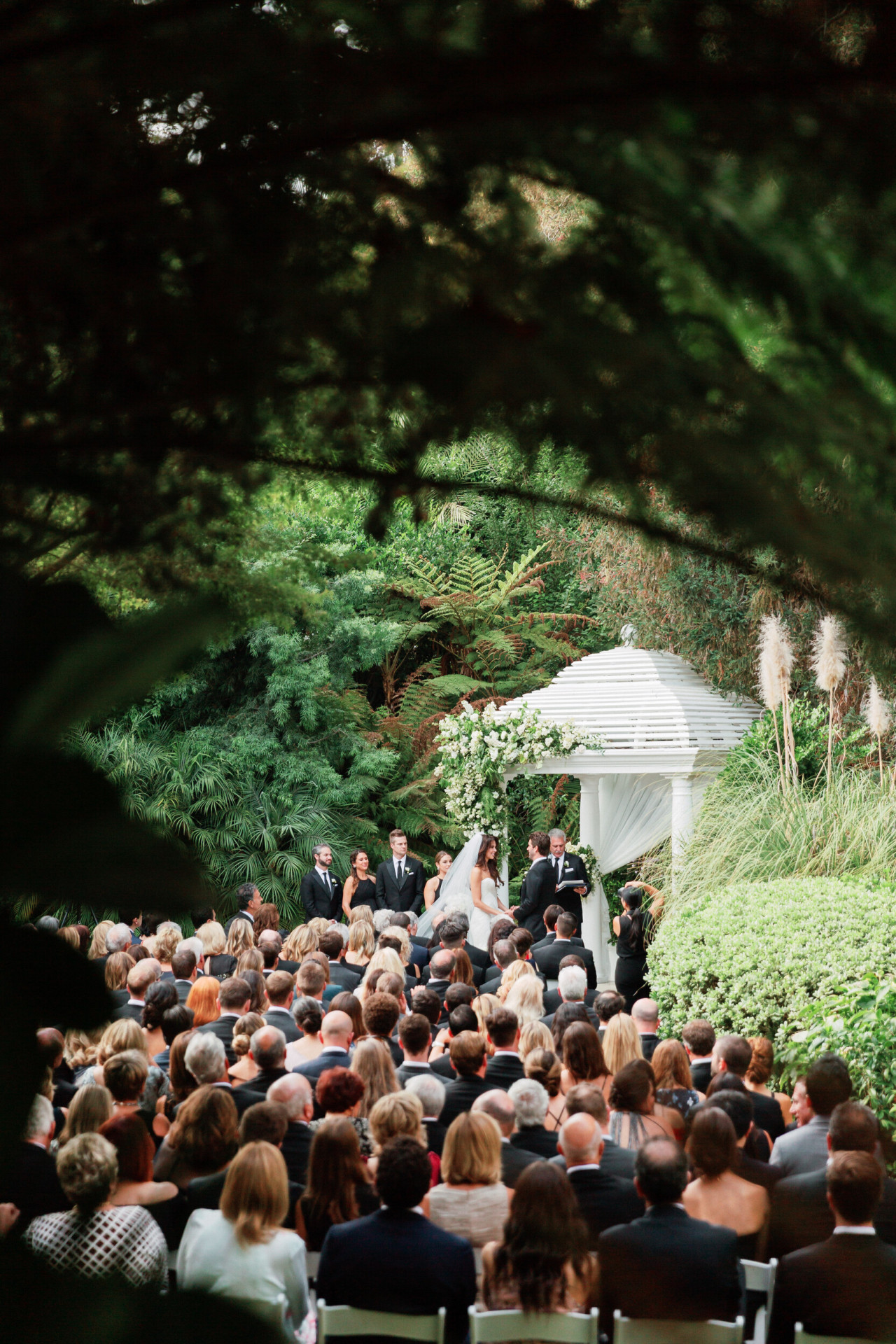 Crowd gathers on Swan Lake for outdoor wedding at Hotel Bel-Air