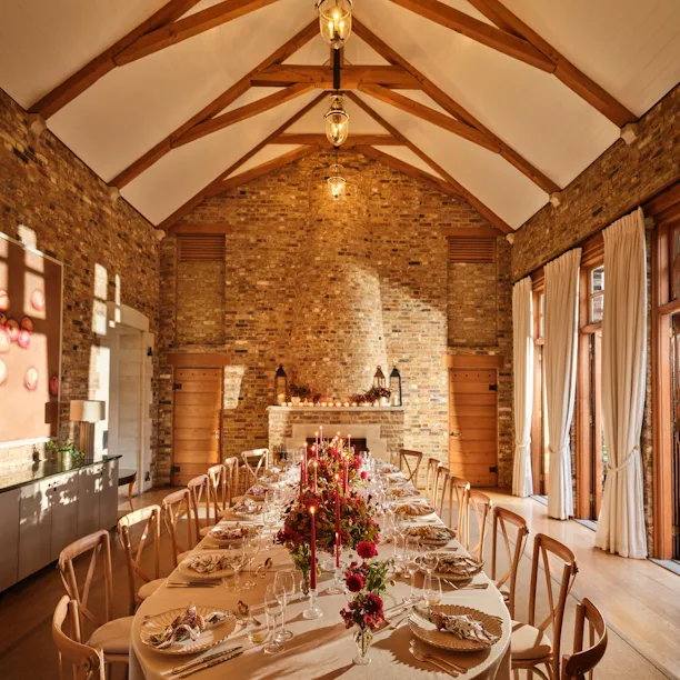 Tower House at Coworth Park set for private dining with rustic beams and stone fireplace