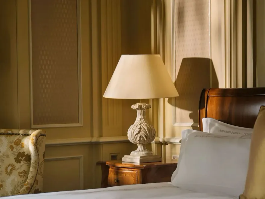 Classic room with soft cream and gold colors, wood details and bedside lamps