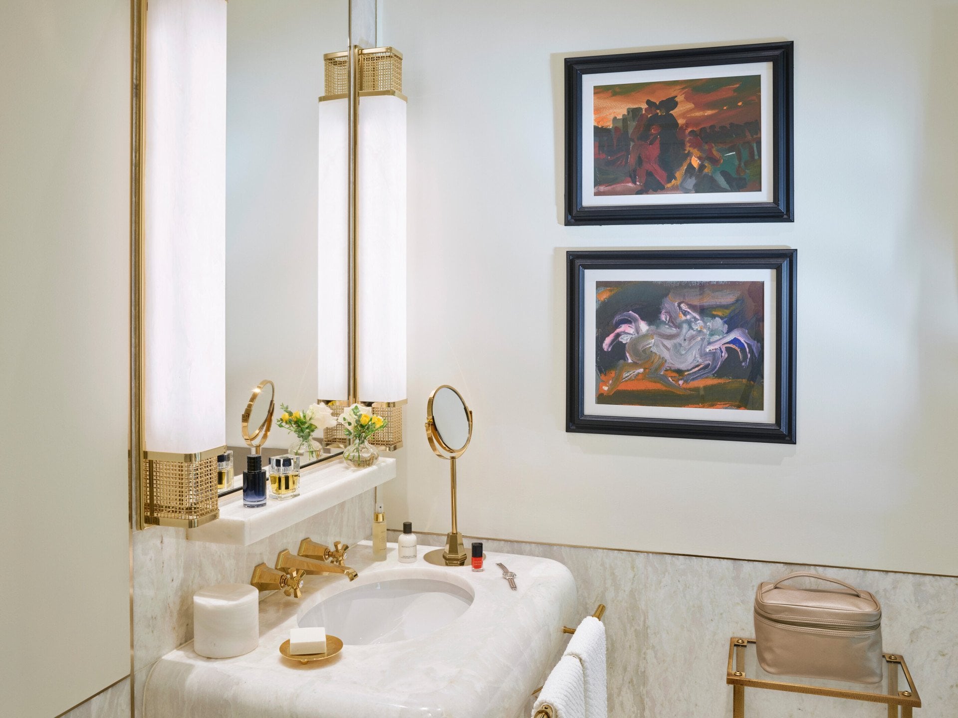 Angolo di un bagno di una camera di Hotel Eden con lavabo in marmo bianco e quadri alla parete