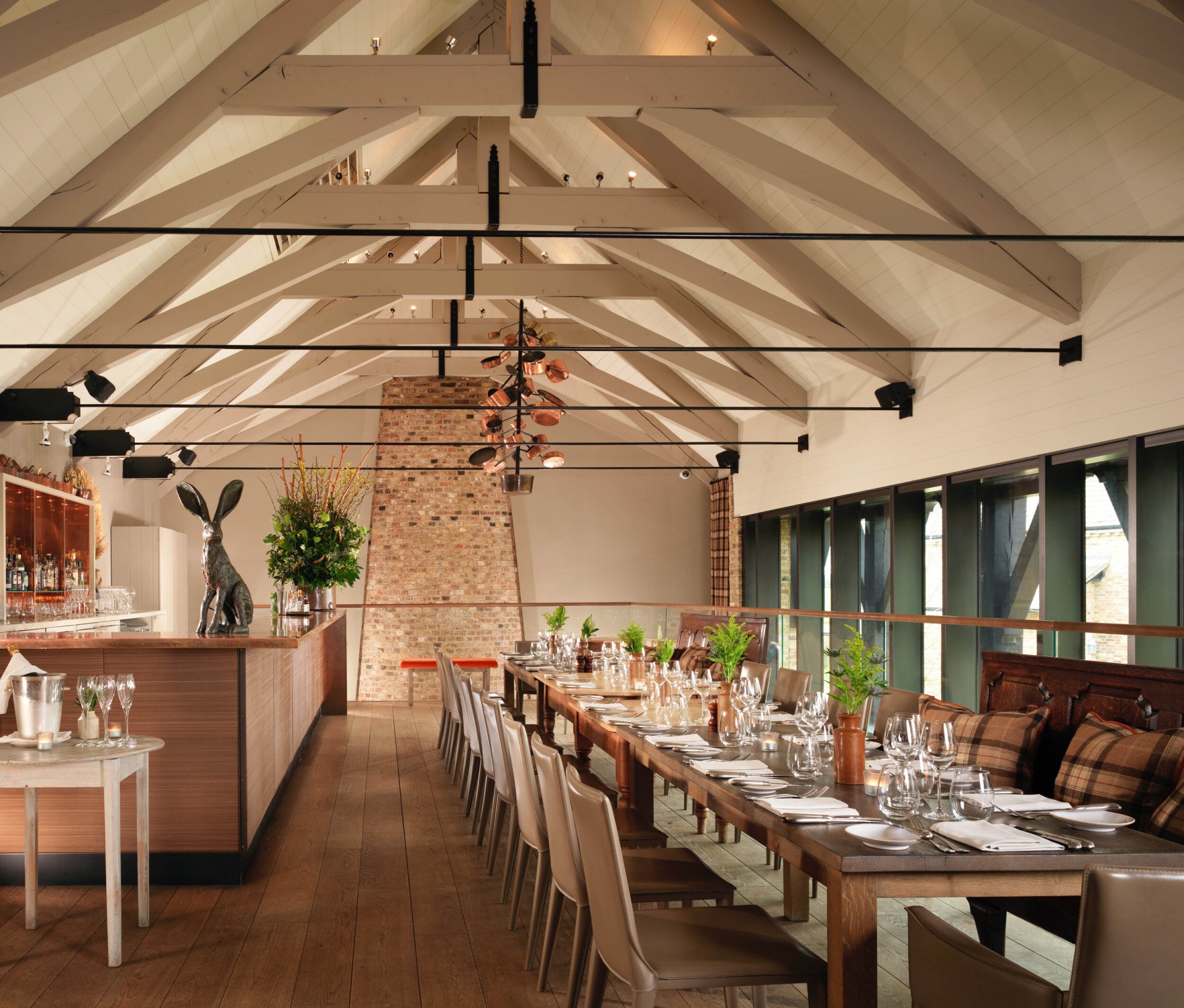 Mezzanine private dining room in The Barn with vaulted ceiling and exposed brick at Coworth Park
