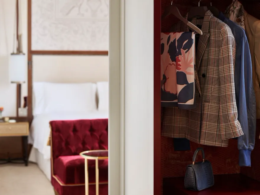 Wardrobe with clothes and bedroom in the background at Dolce Vita Suite at Hotel Eden, Rome