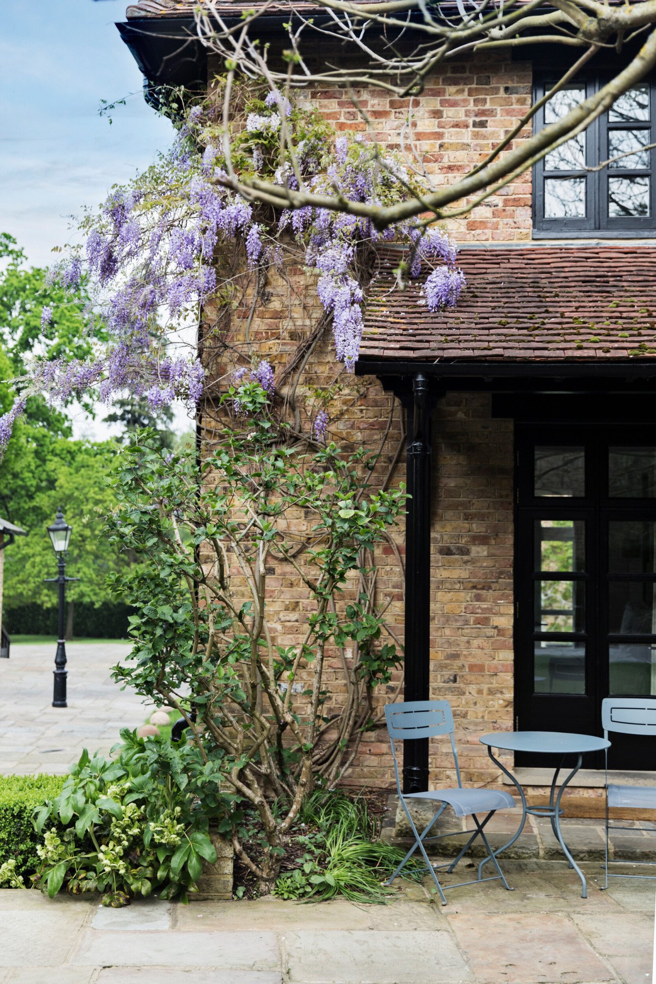 Wisteria-covered courtyard building at Coworth Park with outdoor seating