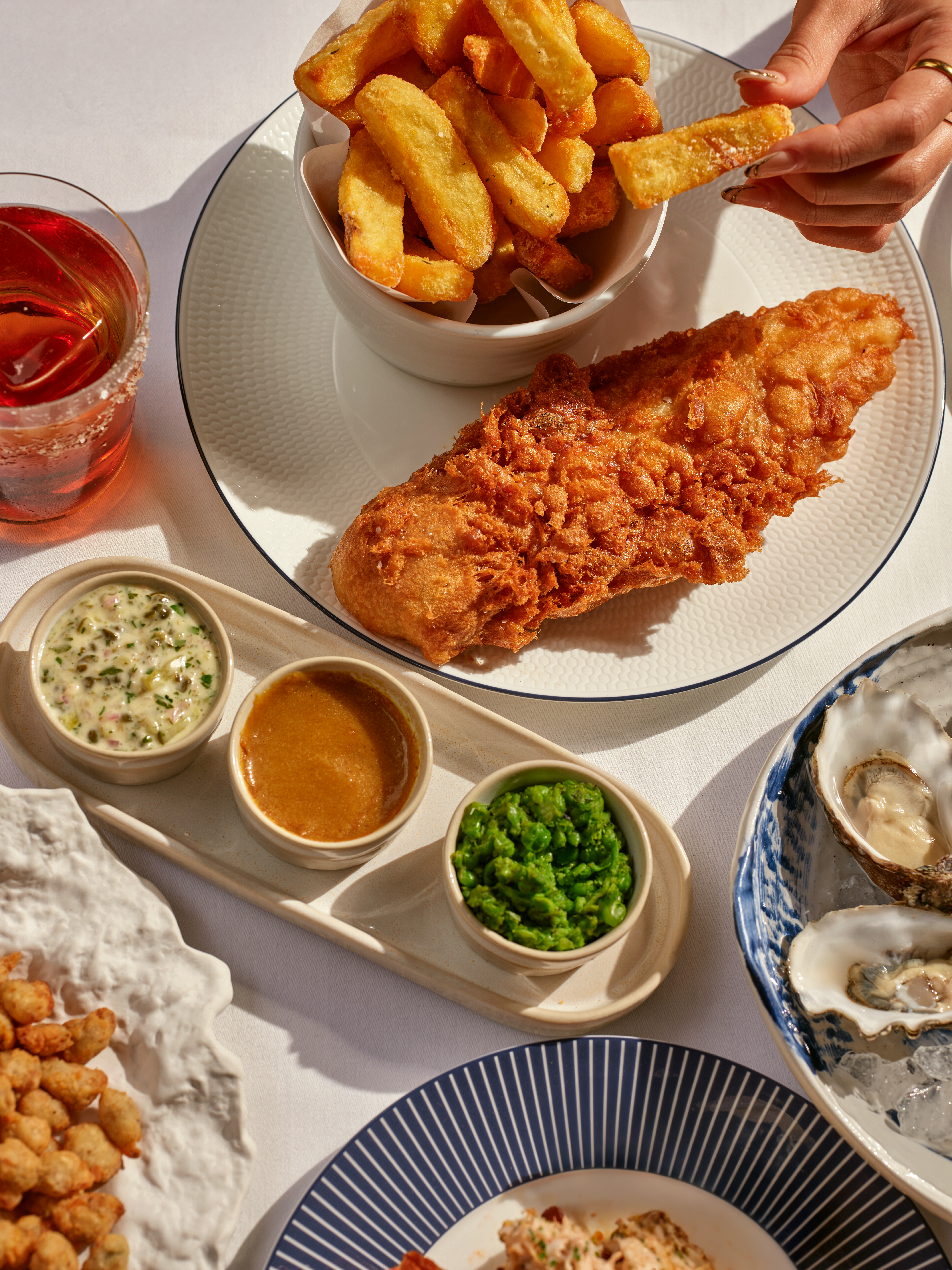 Fish and chips with sides and oysters, flat-lay dining spread at 45 Park Lane