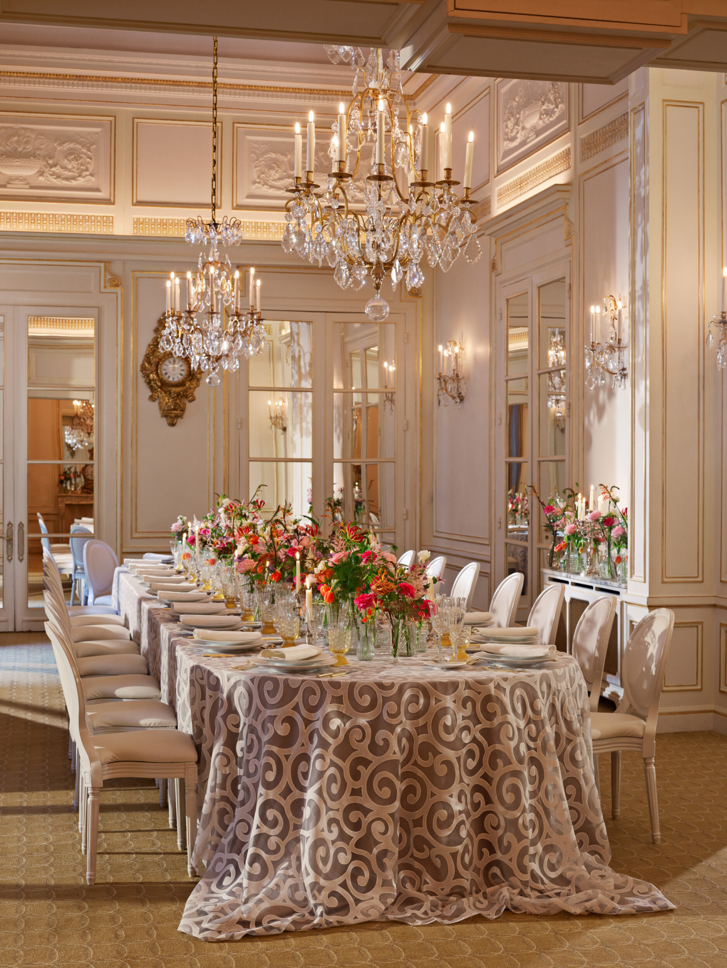 Long table set up with grey tablecloth, colorful flowers captured in Le Salon Organza, at Hôtel Plaza Athénée, Paris - Dorchester Collection.