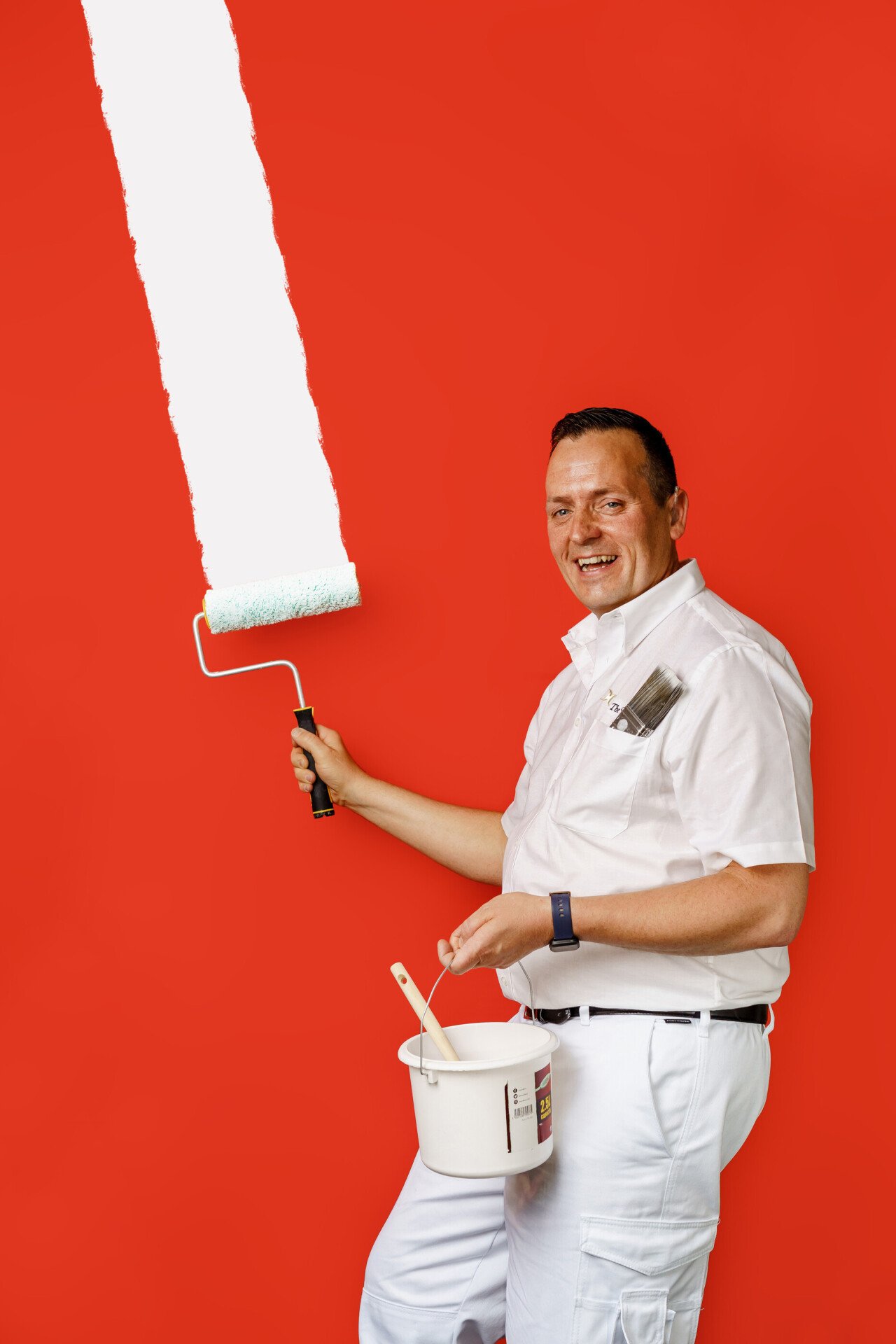 Martin Seymour painting with white paint on a red background