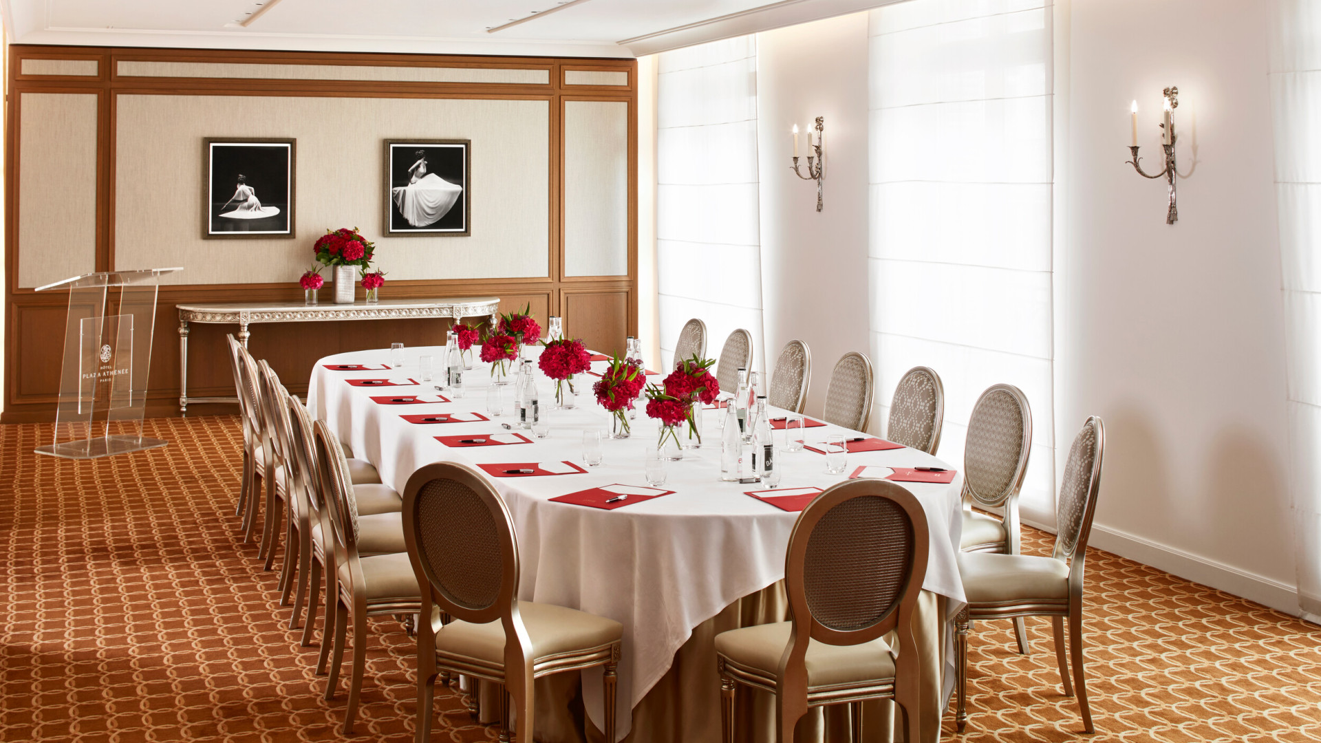 Salon création avec une table ovale de réunion dressée de fleurs et d'équipements pour écrire