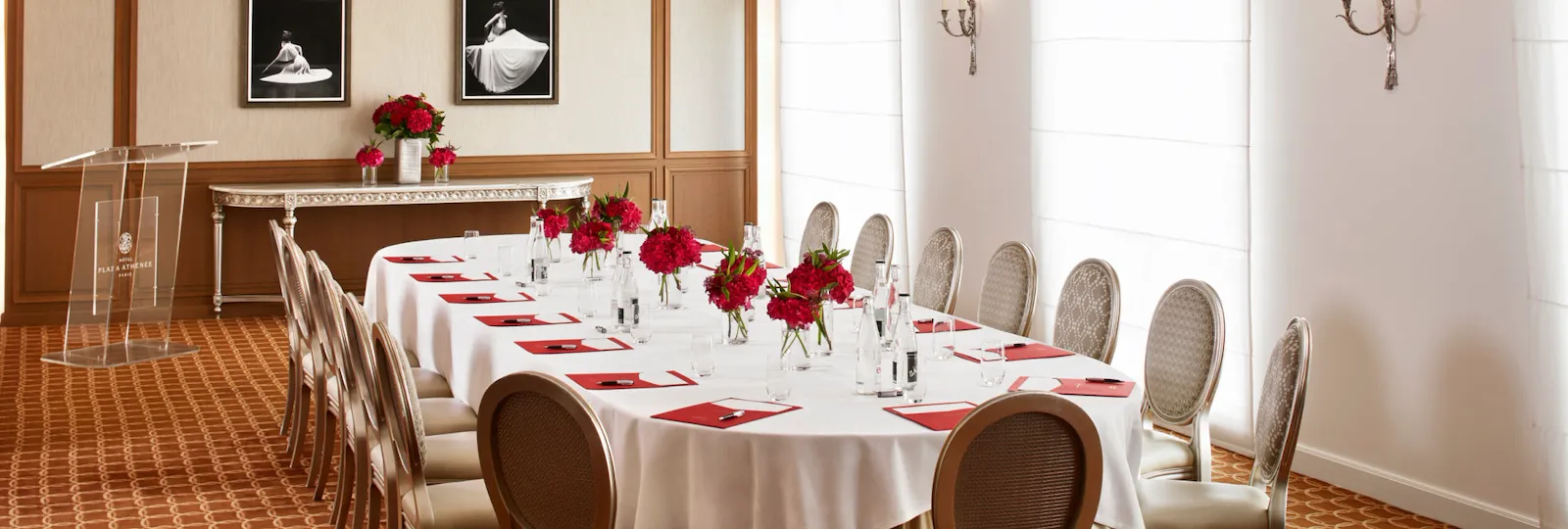 Salon création avec une table ovale de réunion dressée de fleurs et d'équipements pour écrire