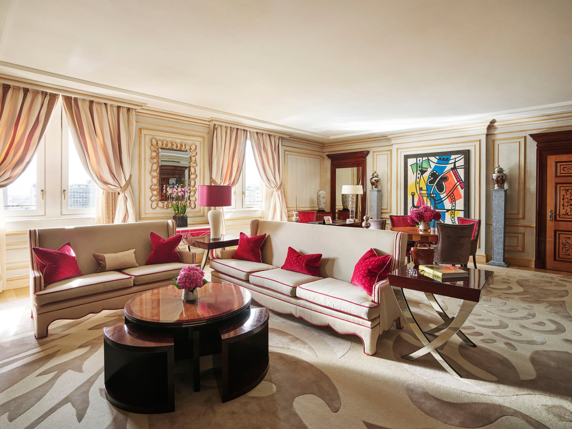 Soggiorno della Imperial Executive Suite arredato con divani bianchi in primo piano e opere d'arte colorate sullo sfondo