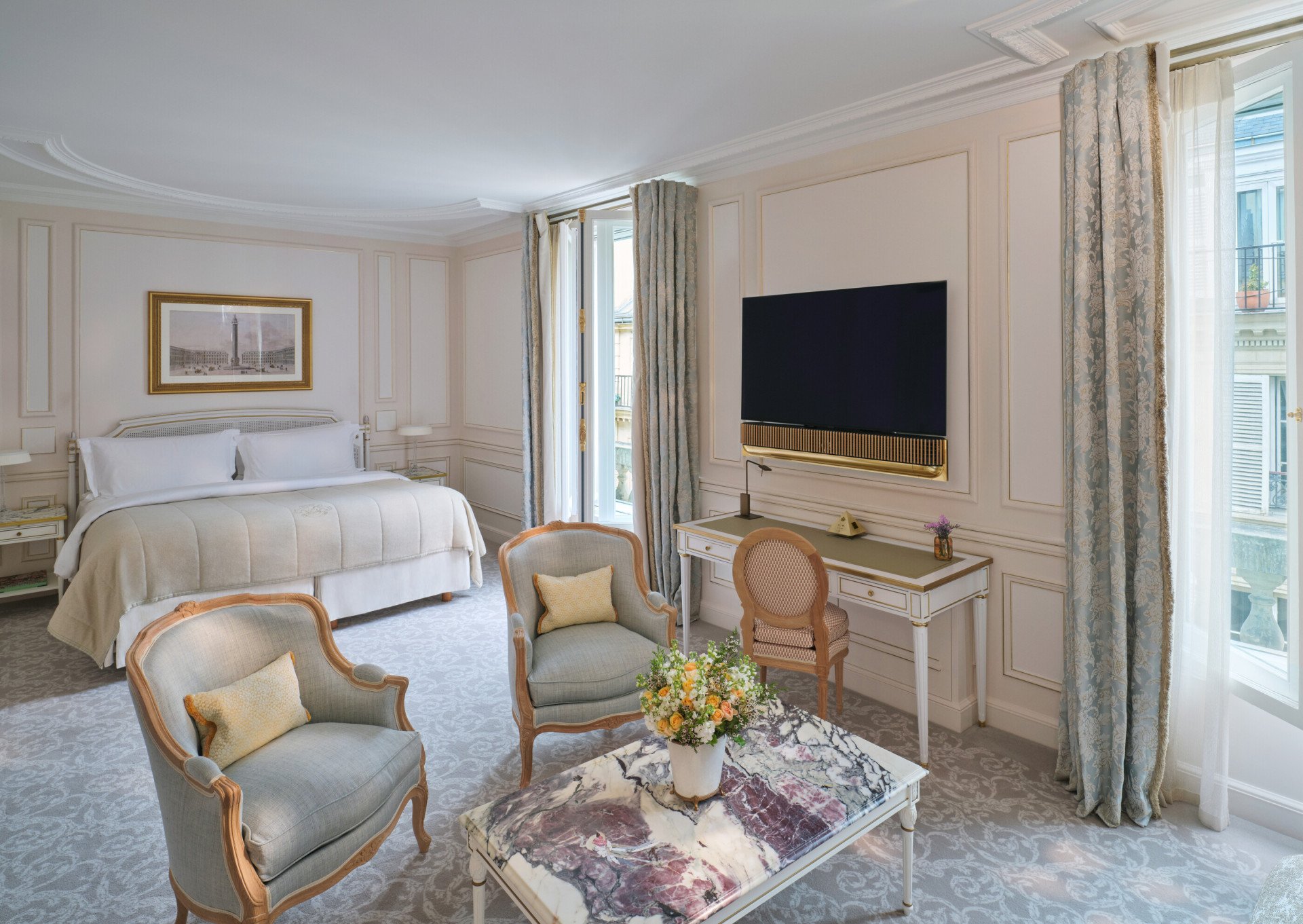 Grande vista da Suíte Junior Deluxe com marquise de pedra sobre a mesa e TV e iluminação na parte traseira, em Meurice, Paris