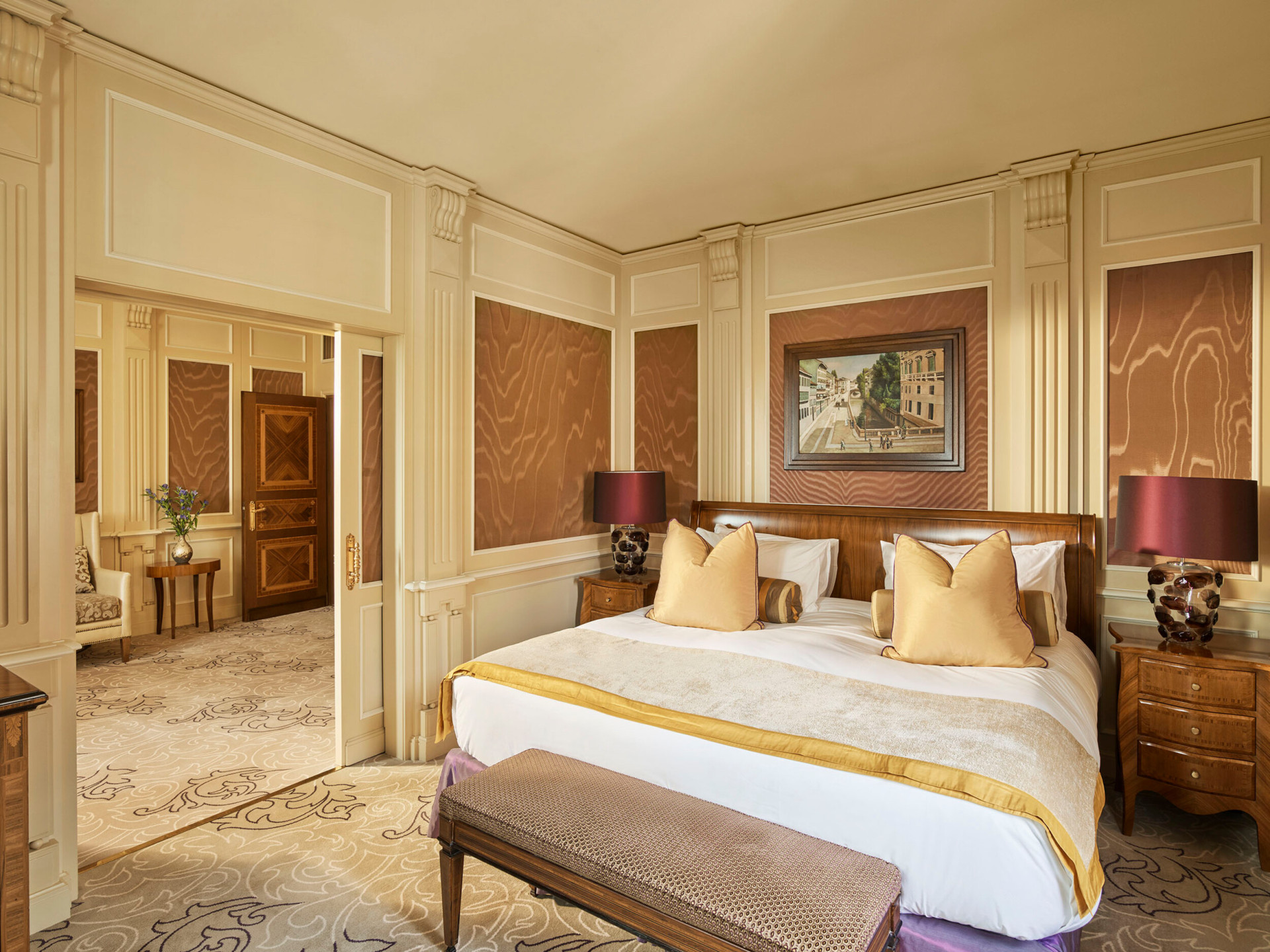 Camera da letto della Suite Ambassador decorata con colori caldi ma anche con tocchi di colore giallo e viola