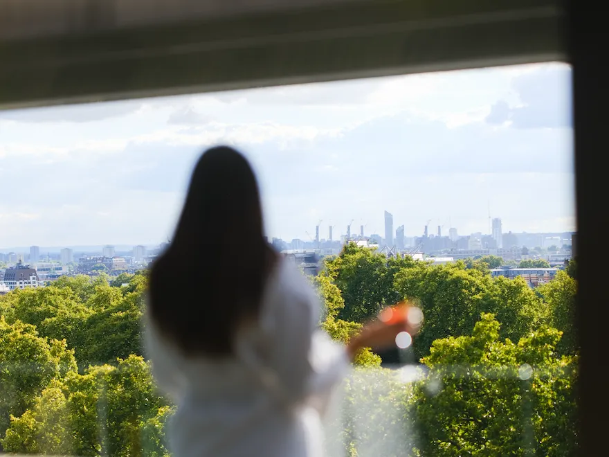 Lady looking over Hyde Park from suite
