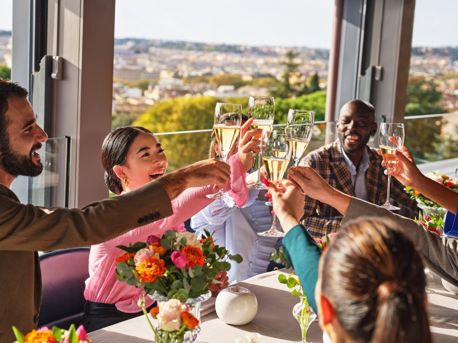 Gruppo di persone sedute ad un tavolo de La Terrazza con i calici alzati per un brindisi