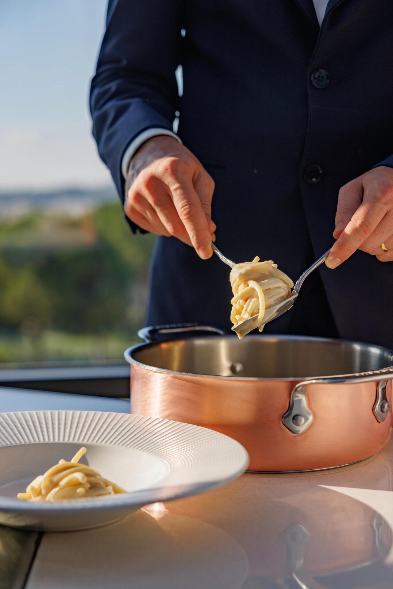 Spaghetti cacio e pepe serviti al tavolo da una pentola di rame a Il Giardino Ristorante
